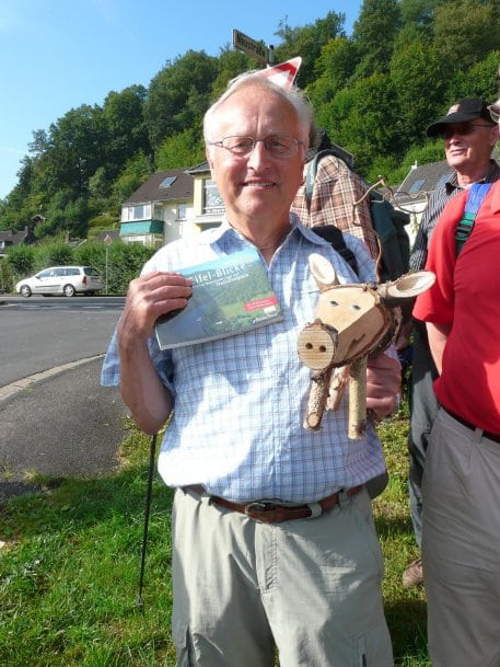 Als Motivation zur Wiederkehr in die Nordeifel gab es für den Jubilar Horst Würtz das Tourenbuch „Eifel-Blicke“ sowie ein Nationalpark-Holzschwein. Foto: Nordeifel Tourismus GmbH
