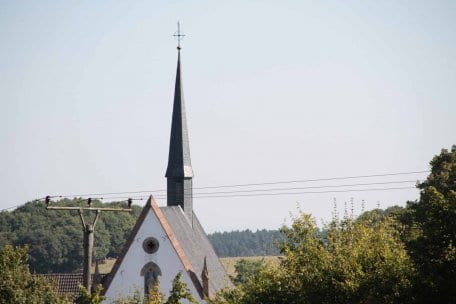 Bild 1: Alle Freileitungen wie hier am Kloster Mariawald werden in den nächsten 15 Jahren im Nationalpark Eifel abgebaut.