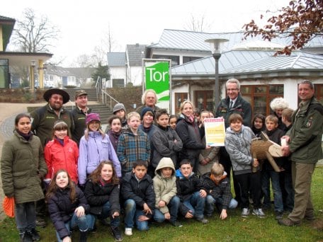 Heinrich Barkmeyer überreicht einer Schulklasse aus Recklinghausen als 1.111.111ster Jubiläumsbesucher der fünf Nationalpark-Tore eine Urkunde.