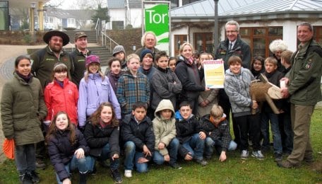 Heinrich Barkmeyer überreicht einer Schulklasse aus Recklinghausen als 1.111.111ster Jubiläumsbesucher der fünf Nationalpark-Tore eine Urkunde.